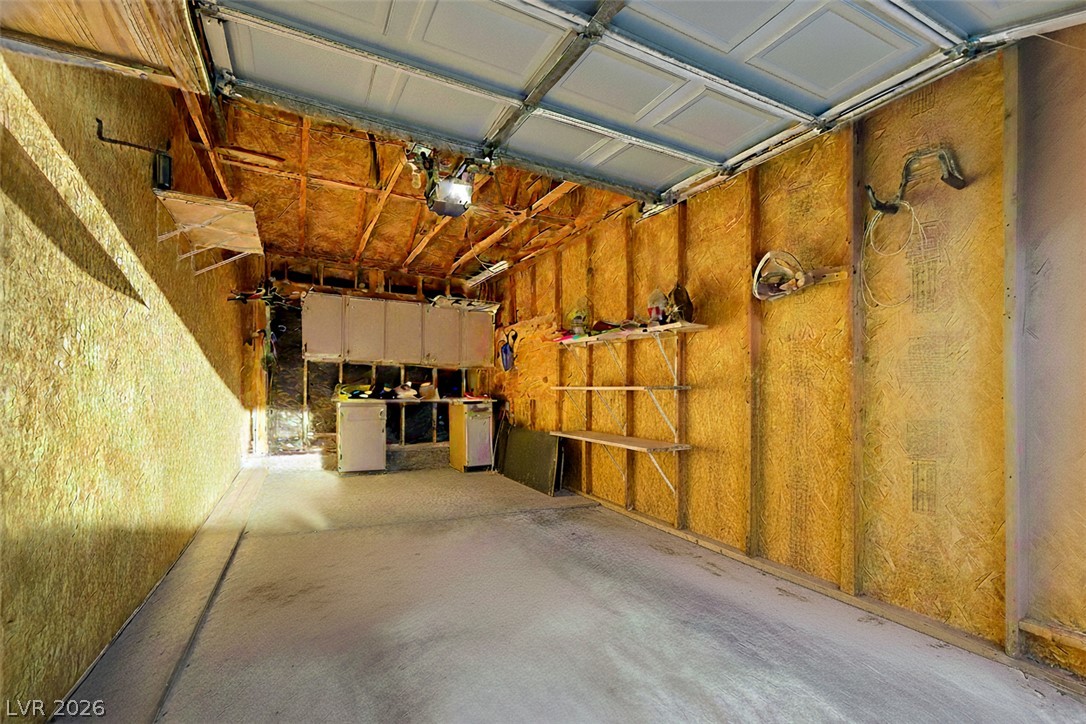 7885 West Flamingo Road, Unit 1071 Las Vegas, NV 89147 - Photo 23 of 28 A utilitarian garage space awaits your vehicle and storage needs, featuring concrete flooring.