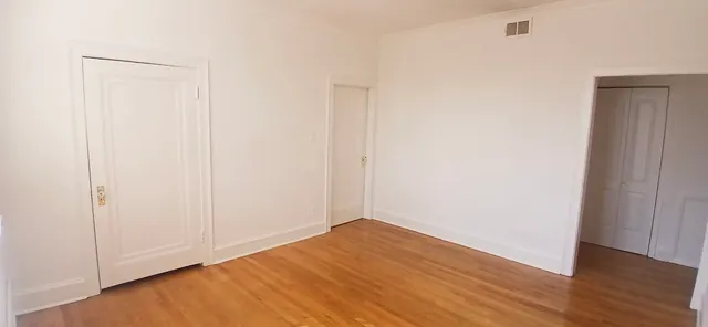a view of empty room with wooden floor