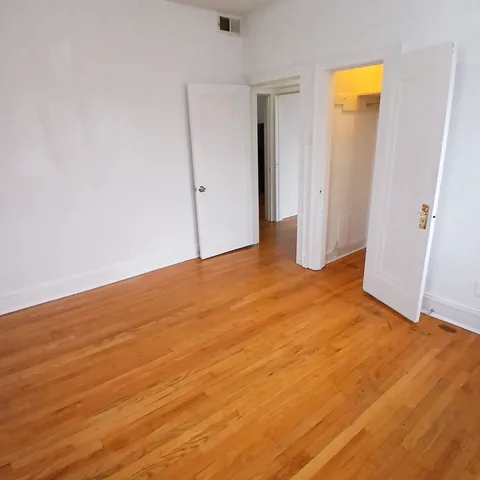 an empty room with wooden floor and closet