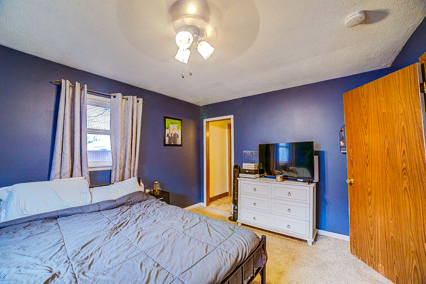 708 Sycamore Street Watseka, IL 60970 - Photo 18 of 25 a bedroom with a bed and a flat tv screen on dresser