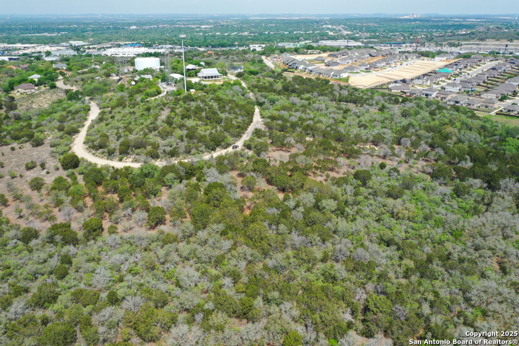 an aerial view of residential houses with outdoor space and trees