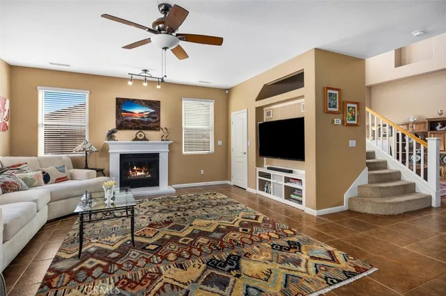 a living room with furniture kitchen view and a large window