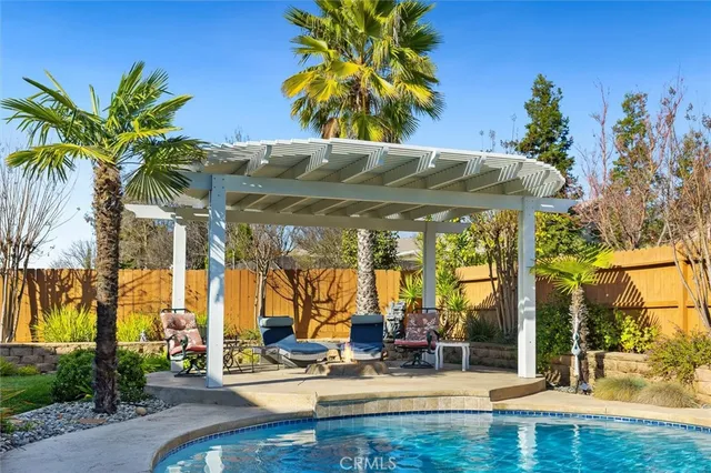 a view of a swimming pool with a patio and a yard