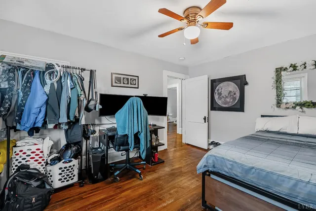 a bedroom with a bed chandelier and a window