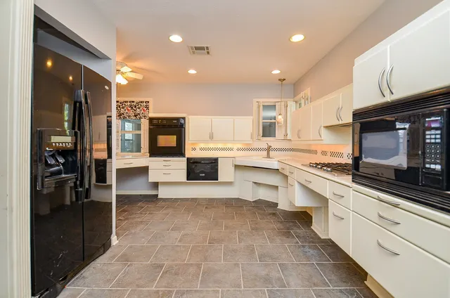 a large kitchen with stainless steel appliances and a stove top oven