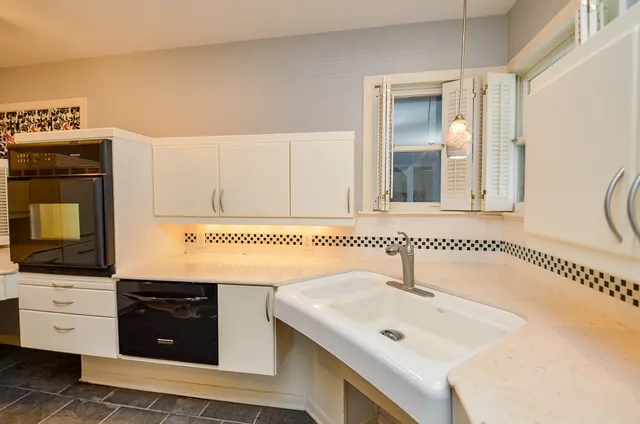 a bathroom with a sink a mirror and cabinets