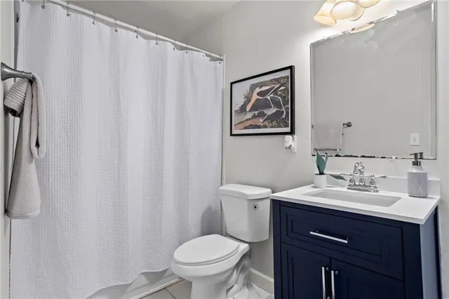 a bathroom with a sink vanity mirror and toilet