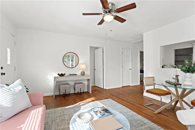 a living room with furniture a clock on wall and a table