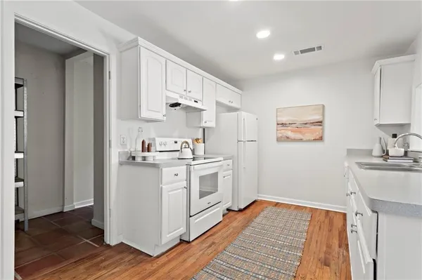 a kitchen with white cabinets and white appliances