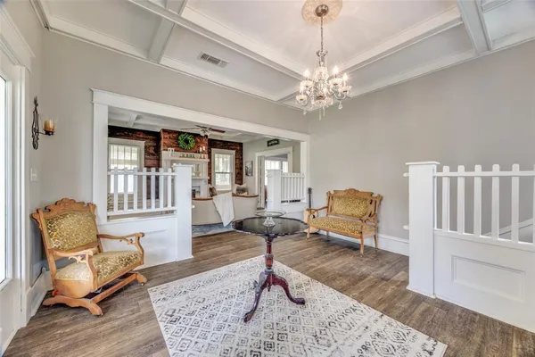 a living room with furniture a piano and a rug