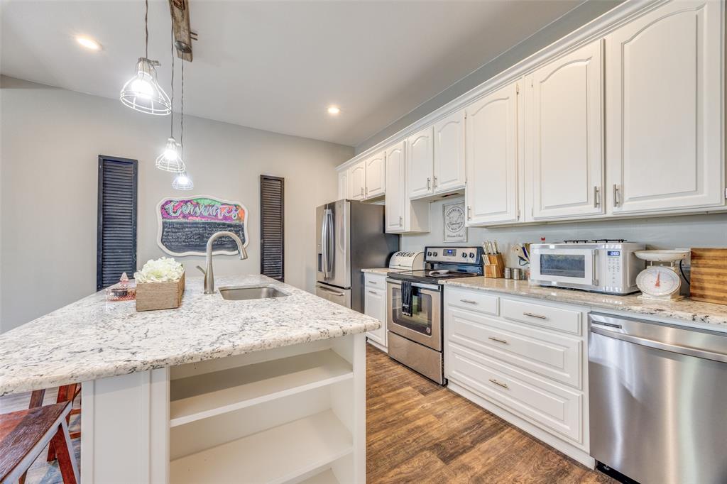 901 North Main Street Leonard, TX 75452 - Photo 10 of 25 a kitchen with granite countertop kitchen island stainless steel appliances a stove refrigerator sink and cabinets