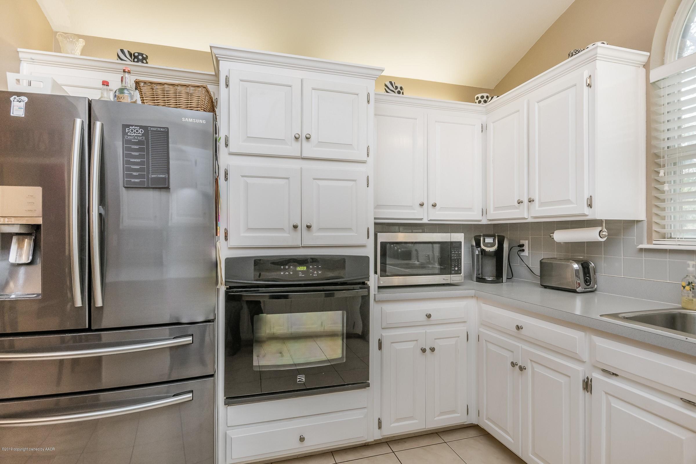 4218 Rondo Avenue Amarillo, TX 79110 - Photo 3 of 20 a kitchen with stainless steel appliances white cabinets and a refrigerator