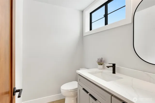 a bathroom with a sink a toilet and a mirror