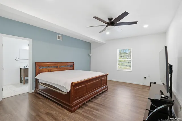 a bedroom with a bed and a ceiling fan