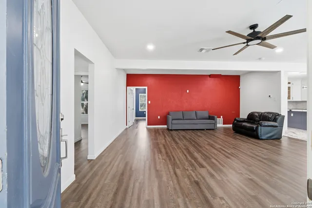 a living room with furniture and a wooden floor