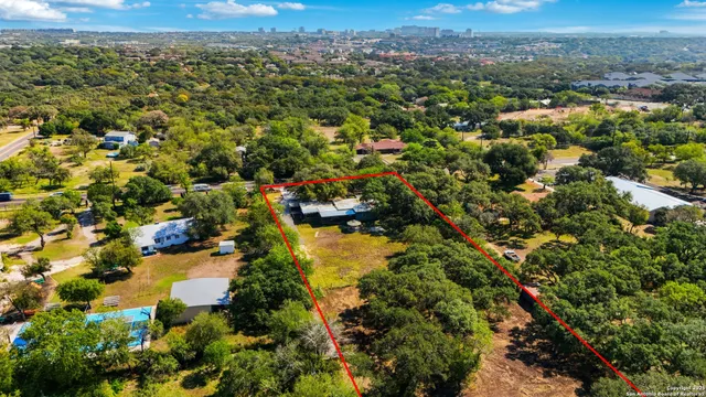 an aerial view of residential houses with outdoor space and trees
