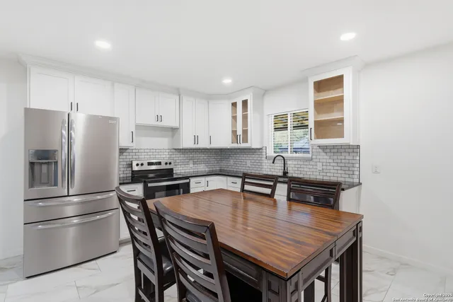 a kitchen with stainless steel appliances granite countertop a kitchen island a table and chairs