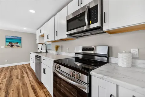a kitchen with a sink cabinets and a window