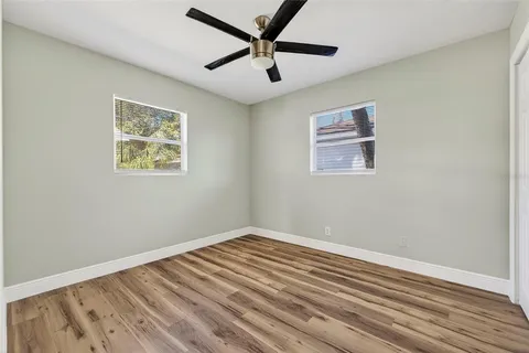 a view of room with wooden floor and ceiling fan