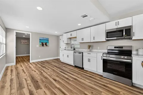 a kitchen with kitchen island white cabinets and white appliances