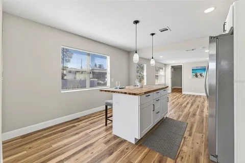 a kitchen with stainless steel appliances granite countertop a sink a stove and a refrigerator