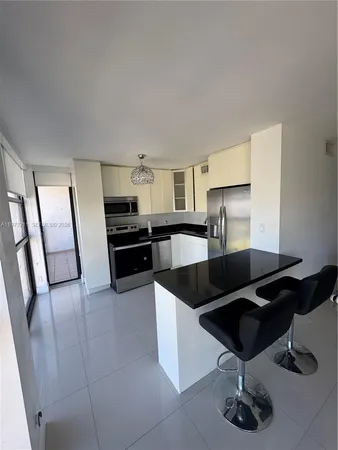 a kitchen with granite countertop a refrigerator and a sink