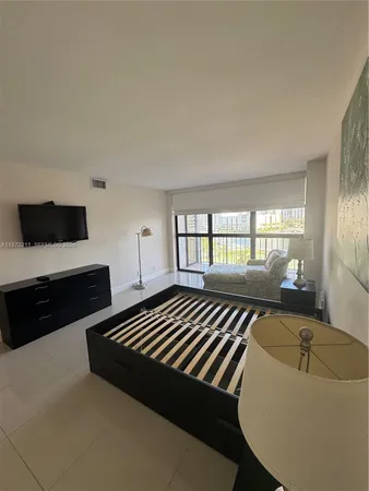 a spacious bedroom with a bed and a large window