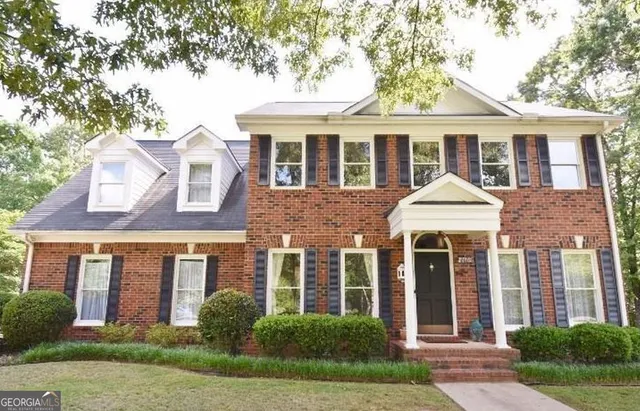 front view of a brick house with a yard