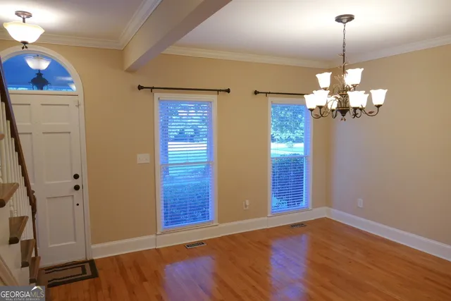 a view of a livingroom with wooden floor and chandelier