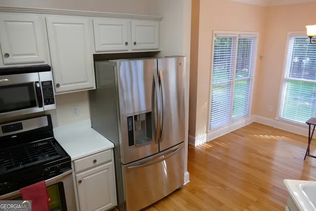 a kitchen with granite countertop a refrigerator stove and cabinets