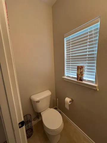 a white toilet sitting next to a window