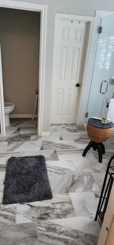 a bathroom with a granite countertop sink and a toilet