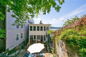 Your own private terrace and Hudson River view from the back of this classic three-family row house in Hasting-on-Hudson.