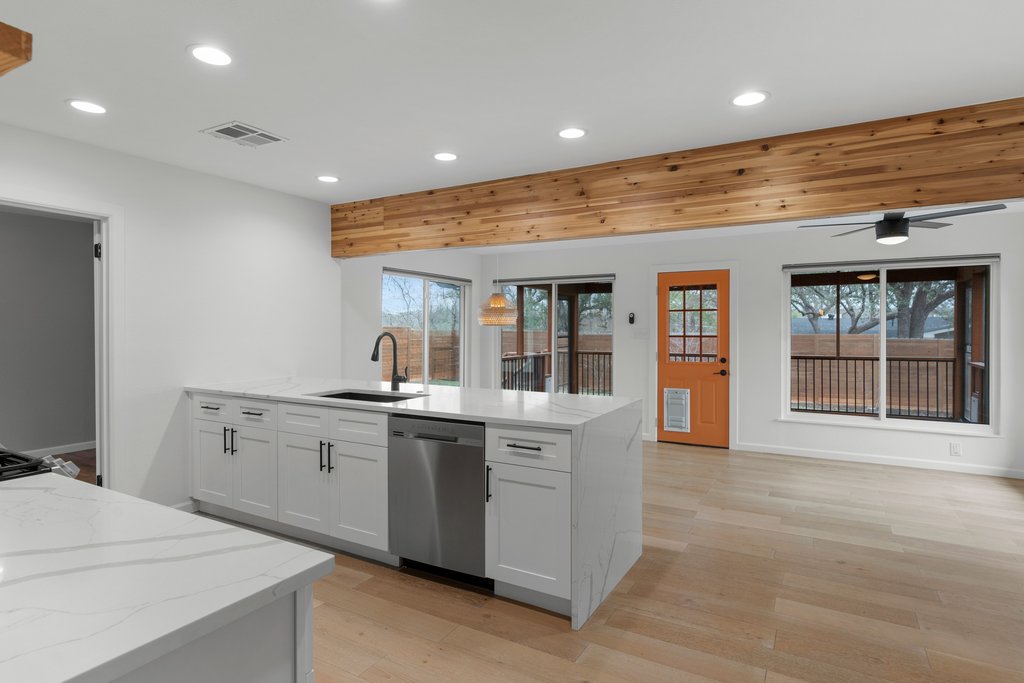 3404 Touchstone Street Austin, TX 78723 - Photo 13 of 32 Kitchen featuring light stone counters, light wood-style floors, stainless steel dishwasher, a peninsula, and recessed lighting