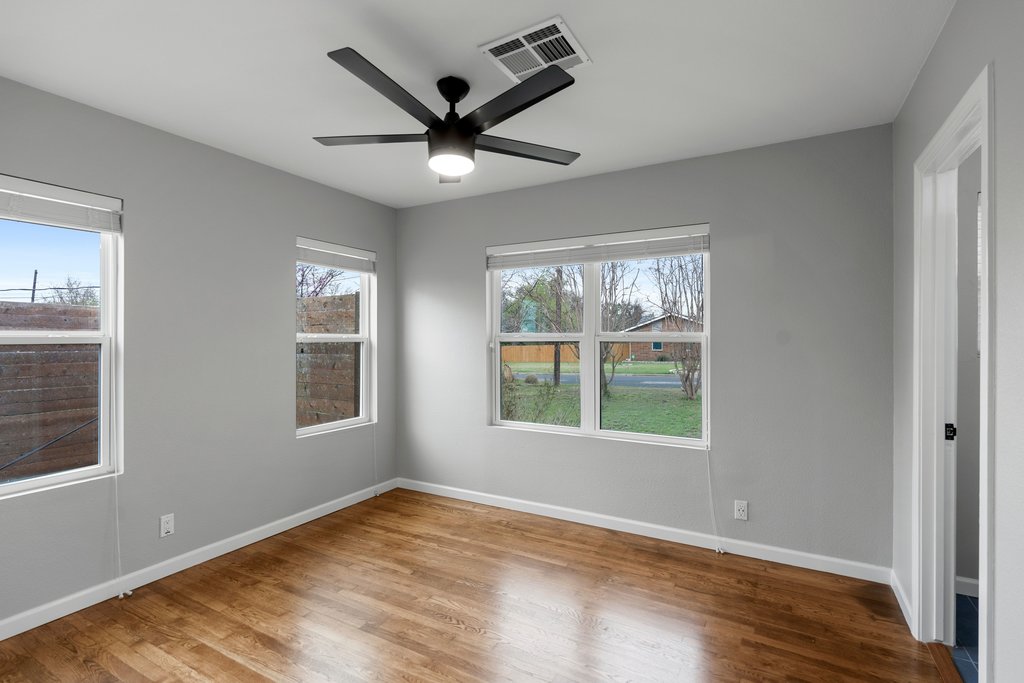 3404 Touchstone Street Austin, TX 78723 - Photo 16 of 32 Unfurnished bedroom with wood finished floors, ceiling fan, and multiple windows