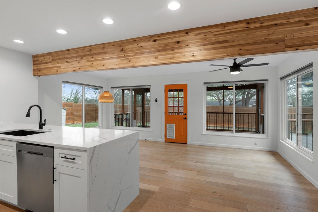 3404 Touchstone Street Austin, TX 78723 - Photo 21 of 32 Kitchen featuring white cabinetry, dishwasher, light wood-type flooring, light stone countertops, and hanging light fixtures