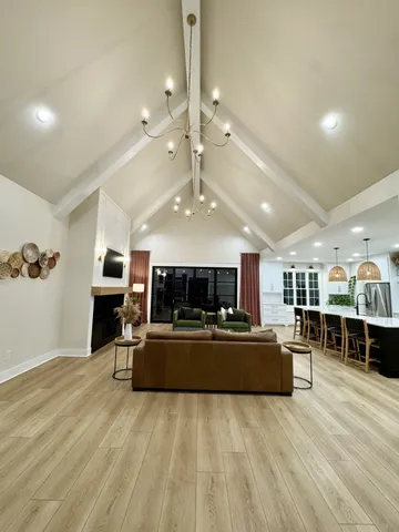 a large living room with stainless steel appliances furniture a fireplace and a view of kitchen