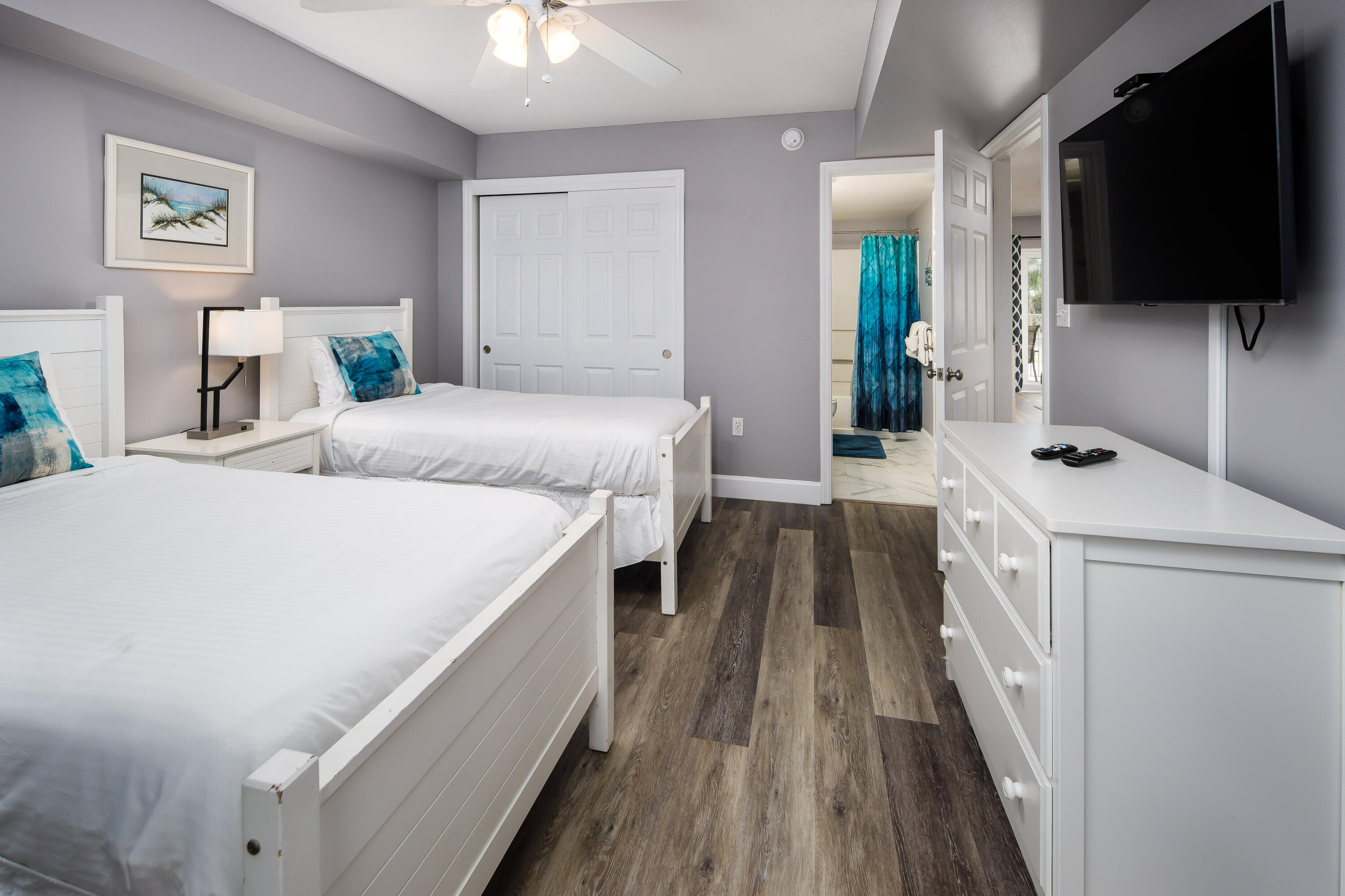 895 Santa Rosa Boulevard, Unit 208 Fort Walton Beach, FL 32548 - Photo 13 of 21 a spacious bedroom with a bed and a flat tv screen on a dresser
