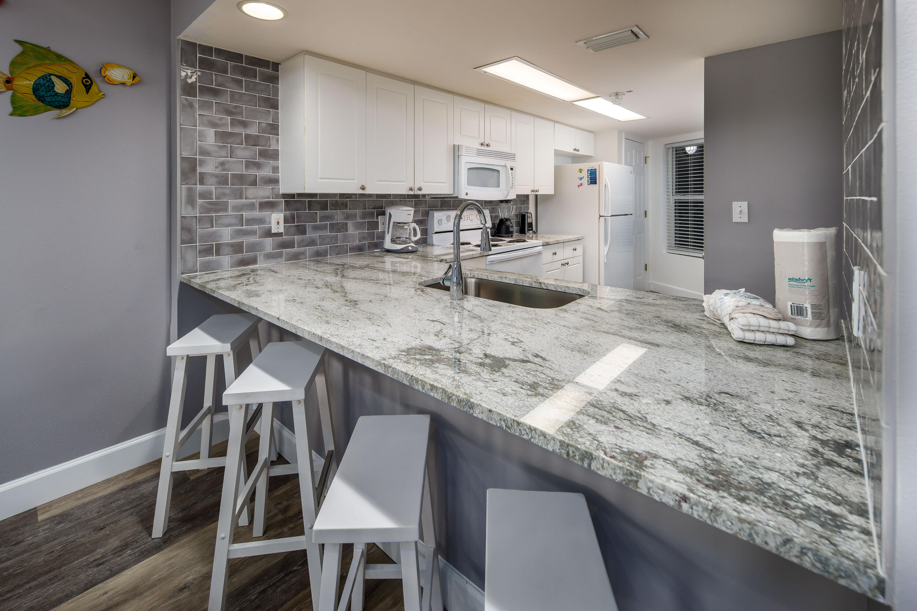 895 Santa Rosa Boulevard, Unit 208 Fort Walton Beach, FL 32548 - Photo 6 of 21 a kitchen with granite countertop kitchen island cabinets and wooden floor