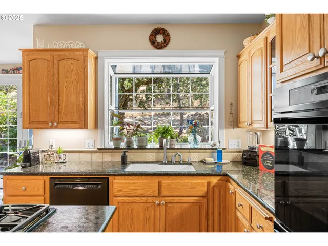 a kitchen with stainless steel appliances granite countertop a sink stove and cabinets