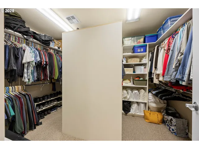 a view of walk in closet with clothes and shoes