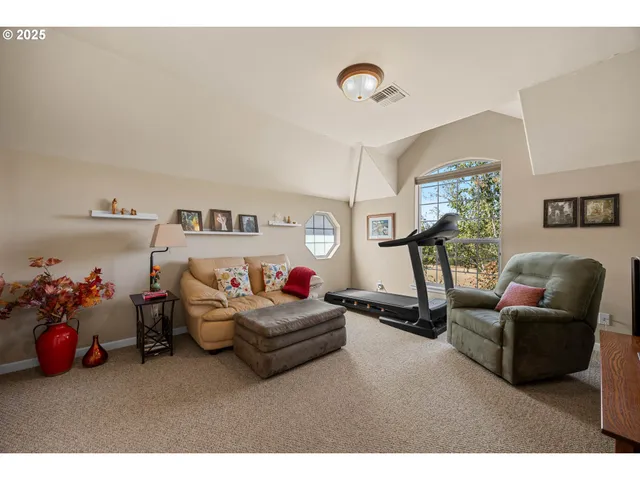 a living room with furniture a window and gym equipment