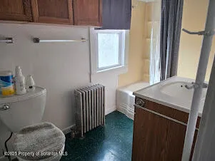 a bathroom with a toilet a sink and a window