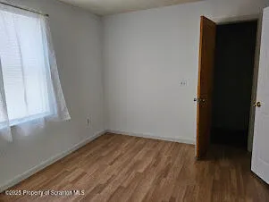 an empty room with wooden floor and closet