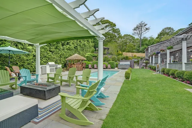 a view of a patio with couches potted plants and a big yard