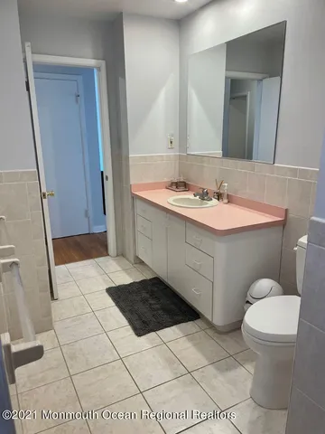 a bathroom with a sink a toilet a mirror and vanity