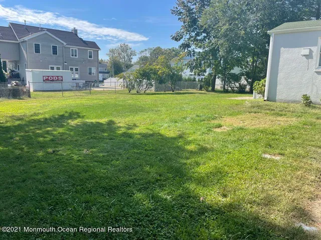 a view of a house with a big yard and large trees