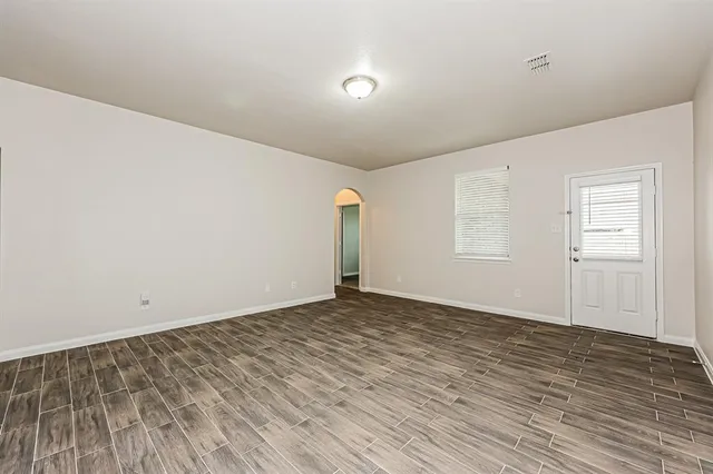 a view of empty room with wooden floor