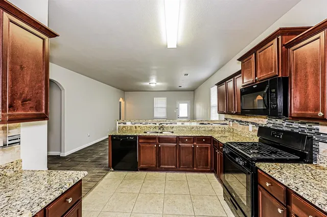 a kitchen with stainless steel appliances granite countertop a stove top oven a sink dishwasher and granite counter top