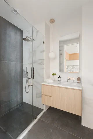 a bathroom with double vanity and a shower